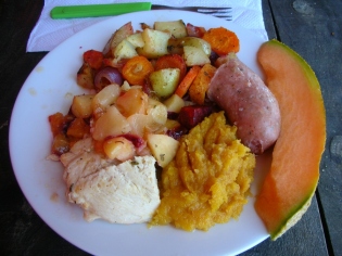 Christmas. Uruguay. Punta del Diablo. Christmas dinner: chicken and chorizo cooked with plums and nectarines, mashed butternut squash seasoned with butter and dulce de leche, roasted veggies, and fresh melon.
